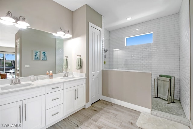 bathroom featuring a tile shower, vanity, and hardwood / wood-style flooring