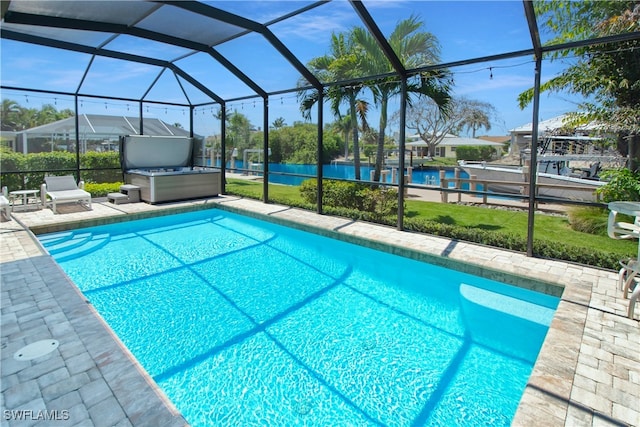 view of swimming pool with glass enclosure, a patio area, and a hot tub