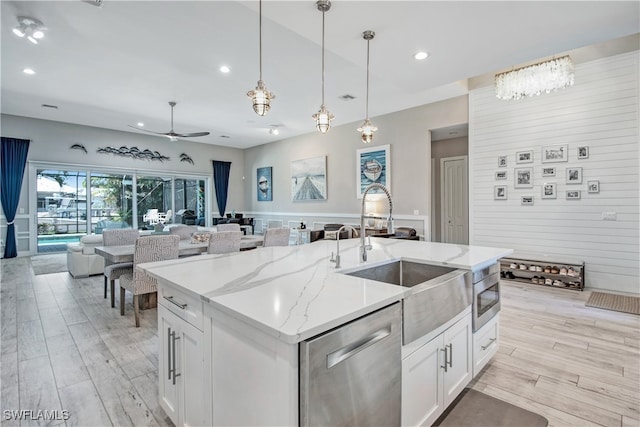 kitchen with white cabinetry, light hardwood / wood-style flooring, ceiling fan, and appliances with stainless steel finishes