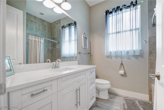 bathroom featuring wood-type flooring, vanity, toilet, and curtained shower