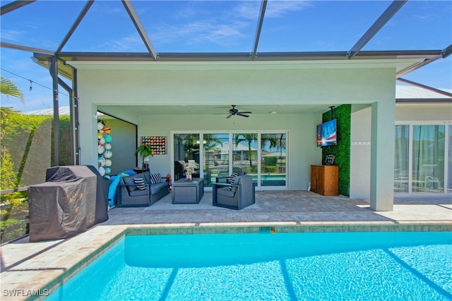 view of swimming pool with a lanai, a patio area, ceiling fan, and an outdoor living space