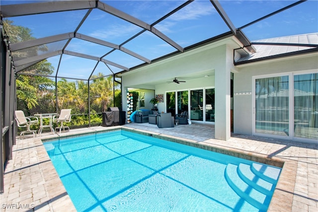 view of swimming pool featuring a patio area, ceiling fan, and glass enclosure