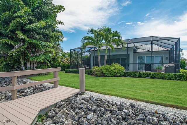 exterior space featuring a lawn and a lanai