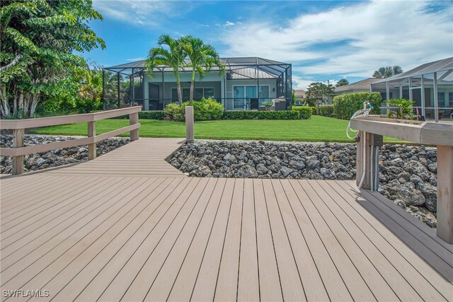 wooden deck featuring a lanai and a lawn