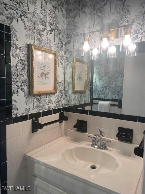 bathroom featuring vanity and tile walls