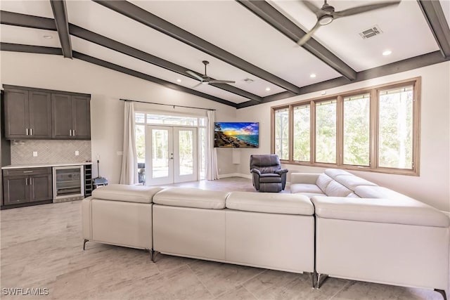 living room with ceiling fan, a healthy amount of sunlight, beverage cooler, and vaulted ceiling with beams