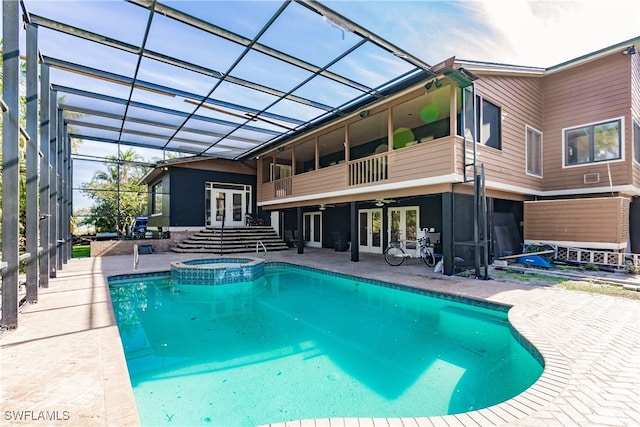 view of swimming pool with a lanai, a patio area, french doors, and an in ground hot tub