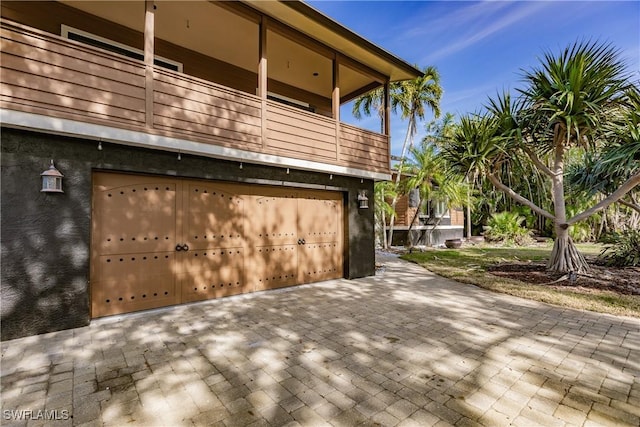 view of side of home with a balcony and a garage