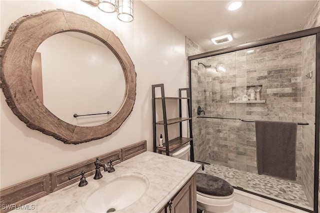 bathroom featuring vanity, toilet, and a shower with door