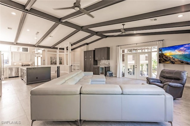 living room featuring french doors, sink, ceiling fan with notable chandelier, and lofted ceiling with beams