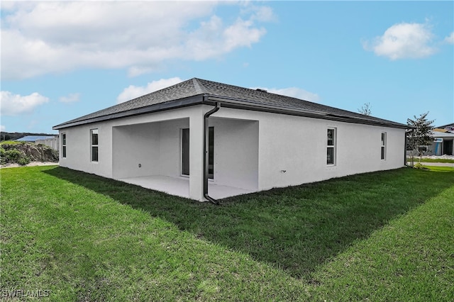 rear view of house featuring a lawn and a patio area