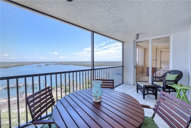 sunroom featuring a water view