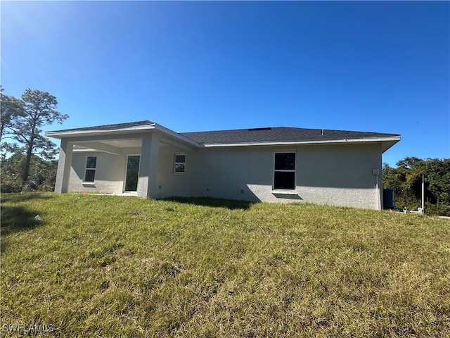 rear view of property with a yard