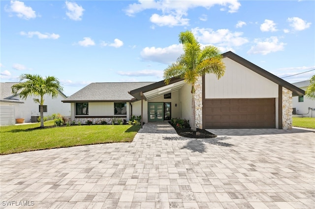 ranch-style house featuring a front yard and a garage