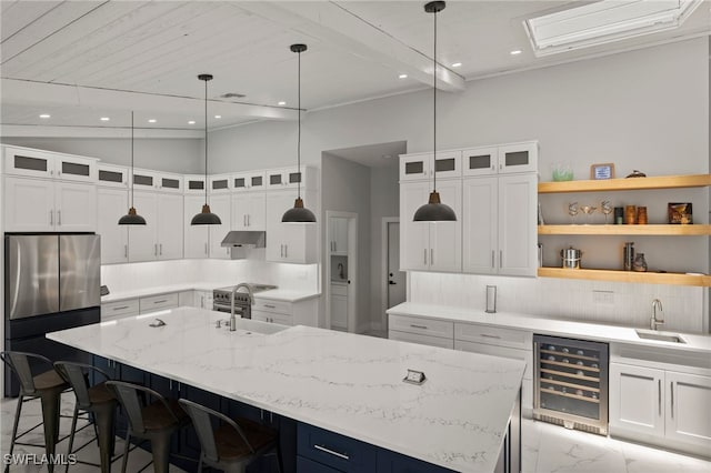 kitchen featuring wine cooler, white cabinets, and a spacious island