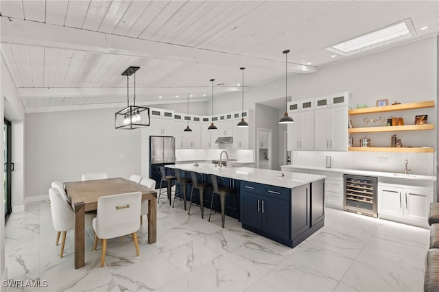 kitchen featuring pendant lighting, white cabinetry, sink, and beverage cooler