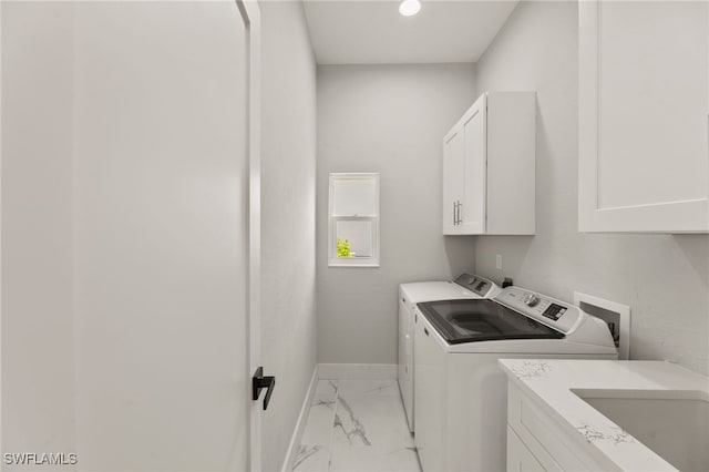 washroom featuring cabinets, sink, and washing machine and dryer