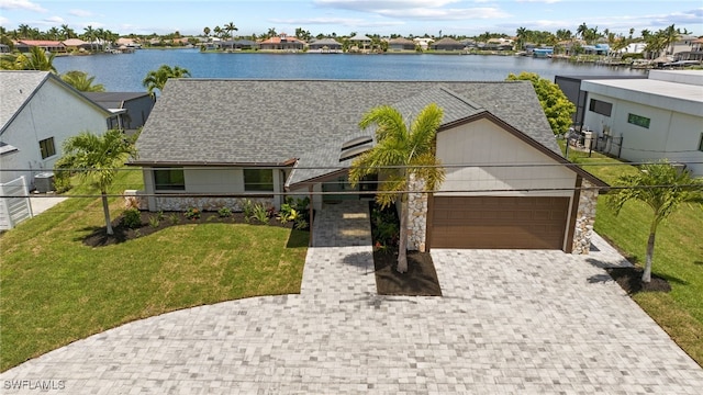 view of front of home with a front lawn, a water view, a garage, and central AC unit