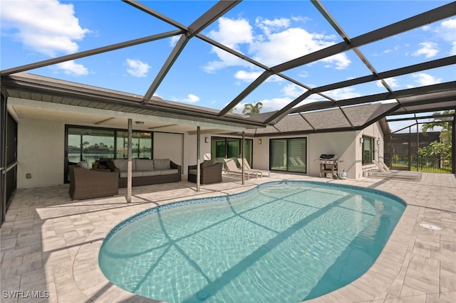 view of swimming pool featuring outdoor lounge area, ceiling fan, a lanai, and a patio