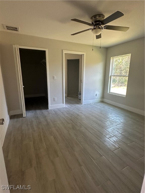 empty room with ceiling fan and dark hardwood / wood-style flooring