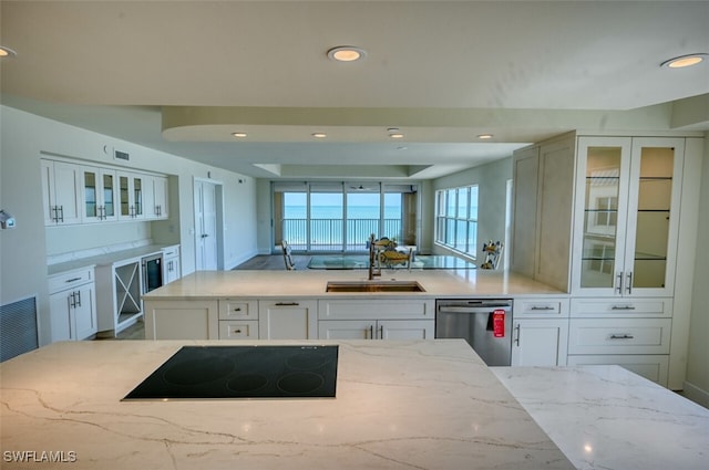 kitchen with dishwasher, white cabinets, sink, black electric cooktop, and light stone counters