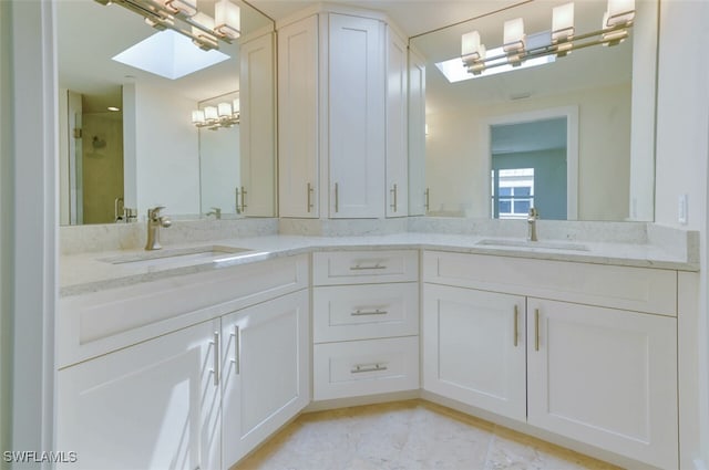 bathroom with vanity, walk in shower, and a skylight