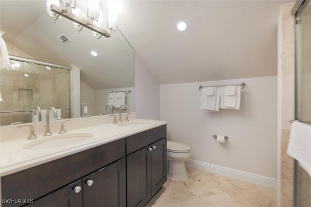 bathroom featuring vanity, toilet, a shower with door, and vaulted ceiling