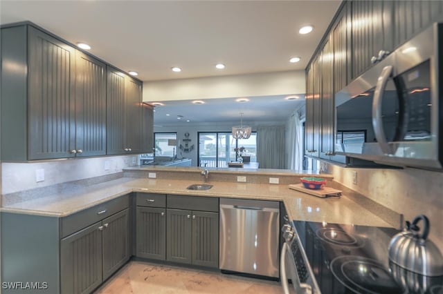 kitchen featuring kitchen peninsula, light stone countertops, stainless steel appliances, sink, and pendant lighting