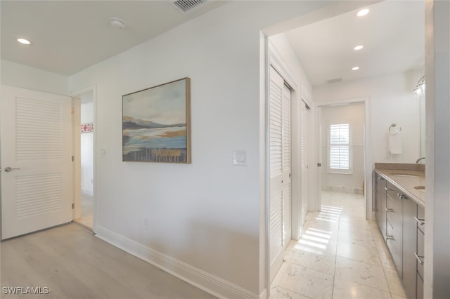 hallway featuring sink and light hardwood / wood-style flooring