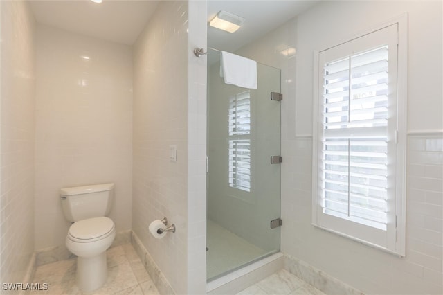 bathroom with toilet, walk in shower, and tile walls