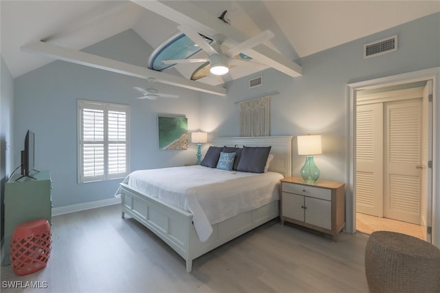 bedroom with ceiling fan, light hardwood / wood-style floors, and vaulted ceiling