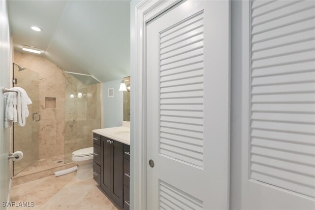 bathroom featuring vanity, lofted ceiling, tile patterned flooring, toilet, and an enclosed shower