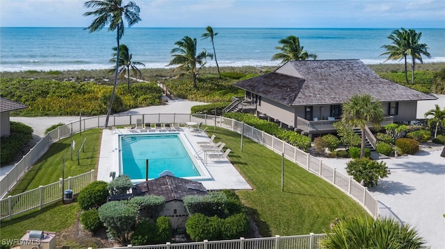 view of swimming pool featuring a lawn, central air condition unit, a water view, and a patio