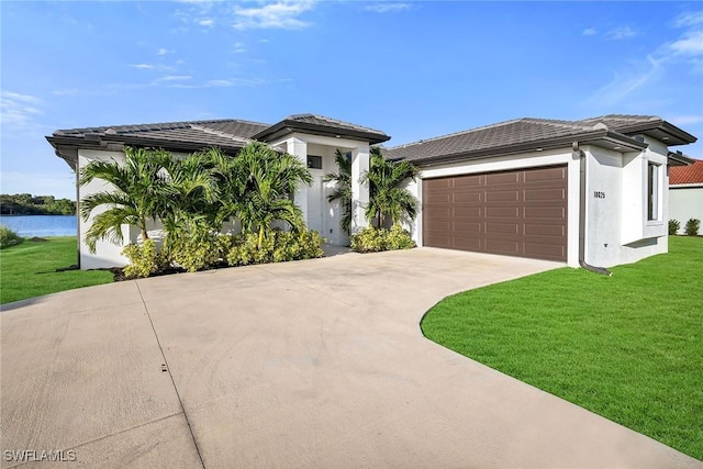 view of front of property with a water view, a garage, and a front yard