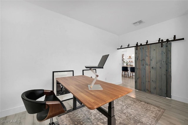 office featuring a barn door and light wood-type flooring