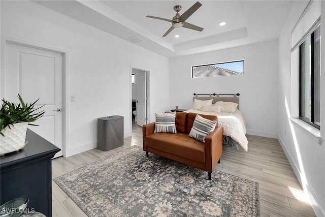 bedroom featuring ceiling fan, light hardwood / wood-style flooring, and multiple windows