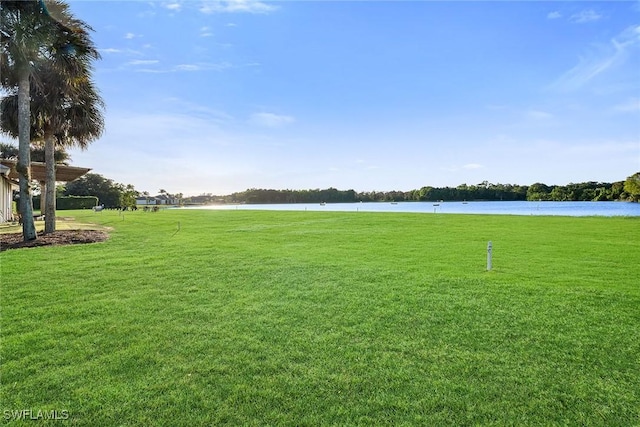 surrounding community featuring a water view and a lawn