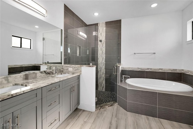 bathroom featuring hardwood / wood-style floors, vanity, and independent shower and bath