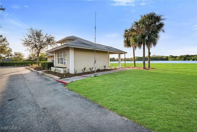 view of property exterior with a lawn and a water view