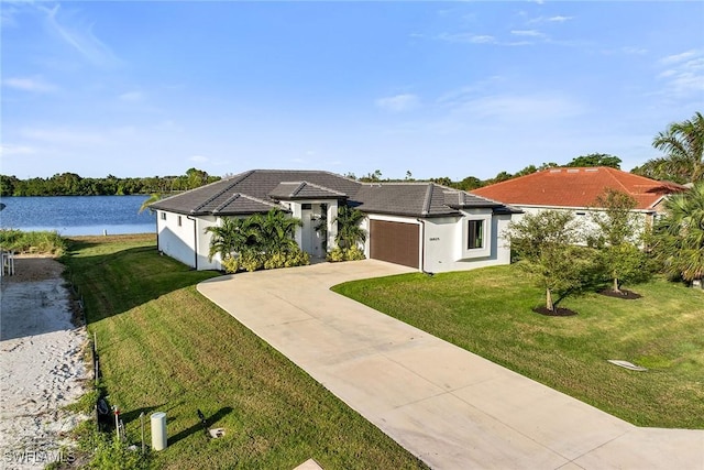 view of front of house featuring a front yard, a water view, and a garage