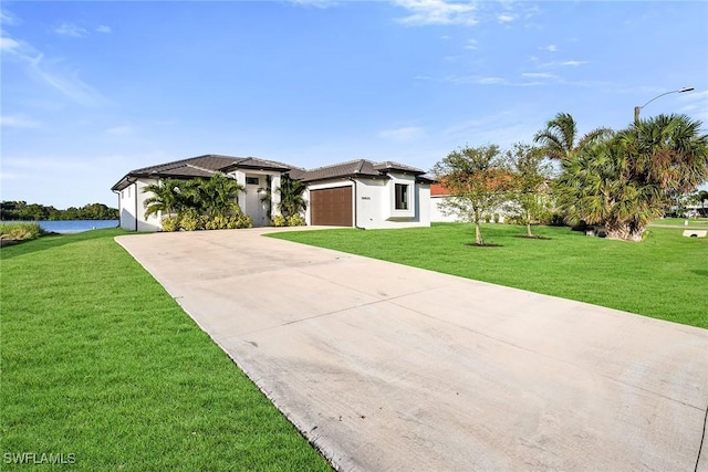 view of front of house with a water view, a front yard, and a garage