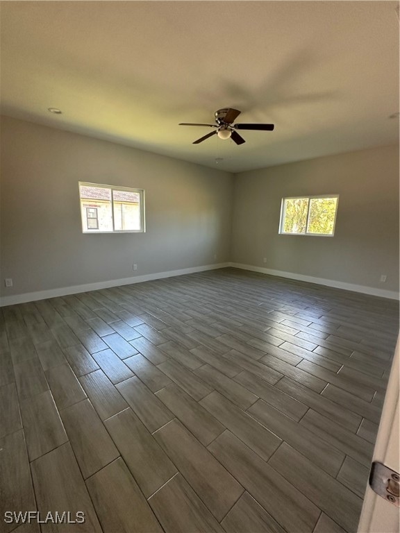 spare room with hardwood / wood-style flooring, a wealth of natural light, and ceiling fan