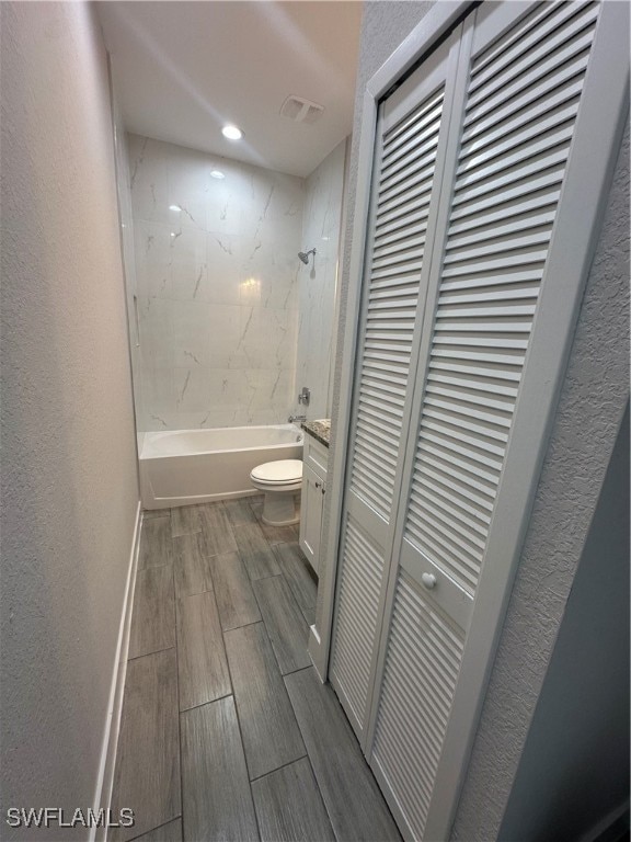 full bathroom featuring vanity, toilet, and tiled shower / bath