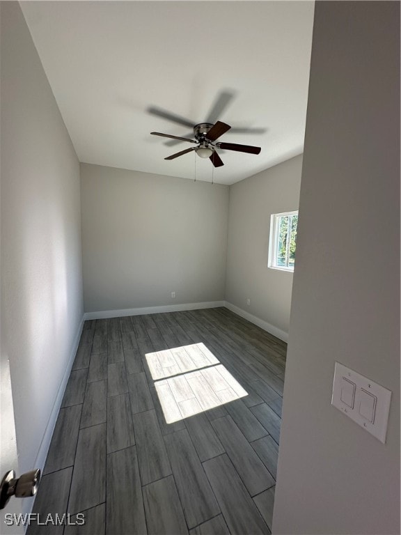 unfurnished room featuring ceiling fan and dark wood-type flooring