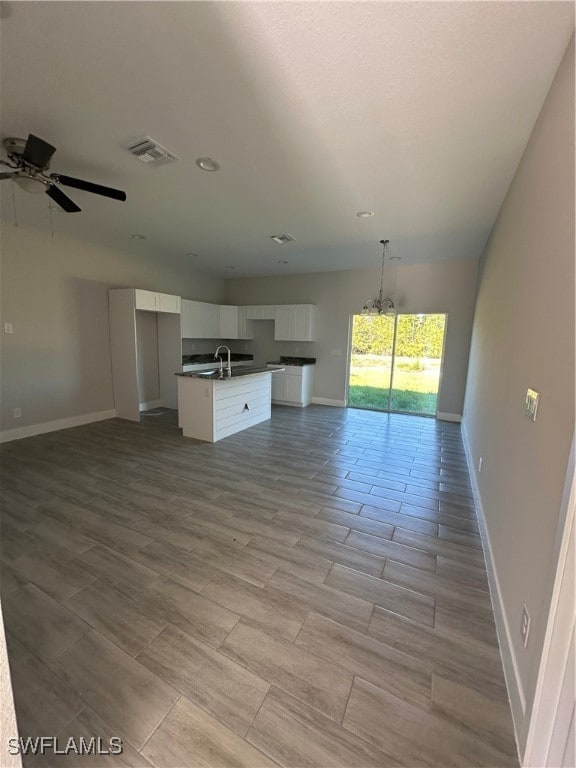 unfurnished living room featuring ceiling fan, sink, and light hardwood / wood-style floors