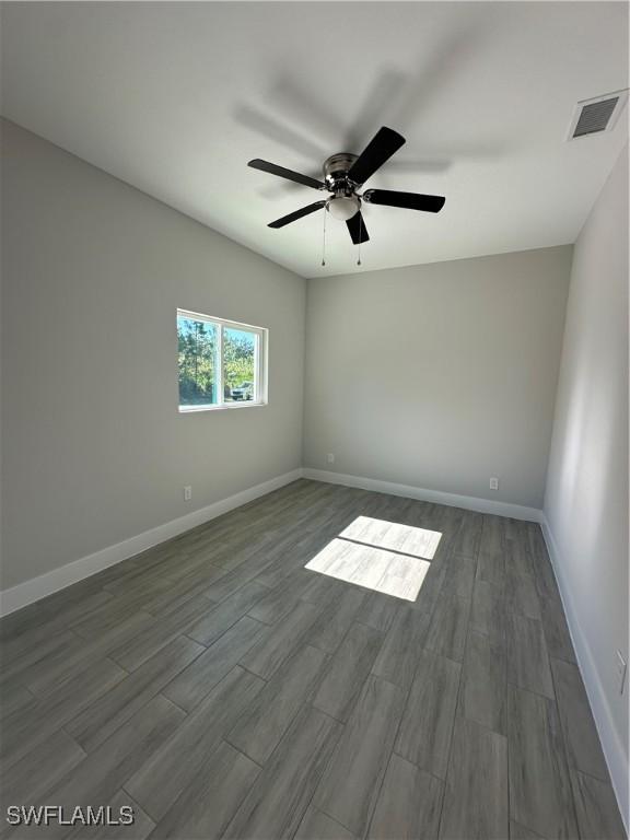 empty room with ceiling fan and wood-type flooring