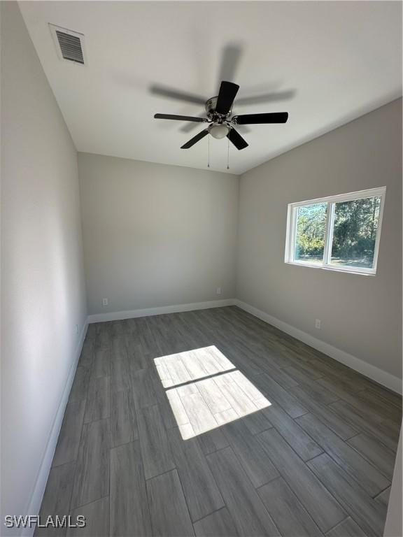 spare room featuring ceiling fan and dark wood-type flooring