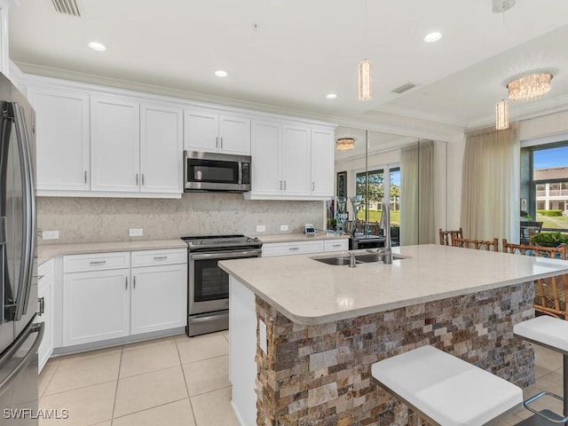 kitchen with a kitchen breakfast bar, a wealth of natural light, hanging light fixtures, and appliances with stainless steel finishes