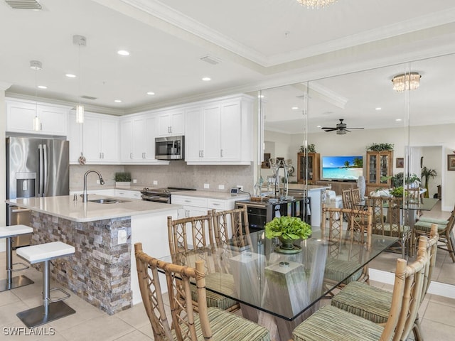 kitchen with stainless steel appliances, sink, pendant lighting, light tile patterned floors, and white cabinets