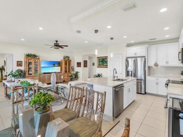 kitchen with pendant lighting, white cabinets, sink, an island with sink, and appliances with stainless steel finishes